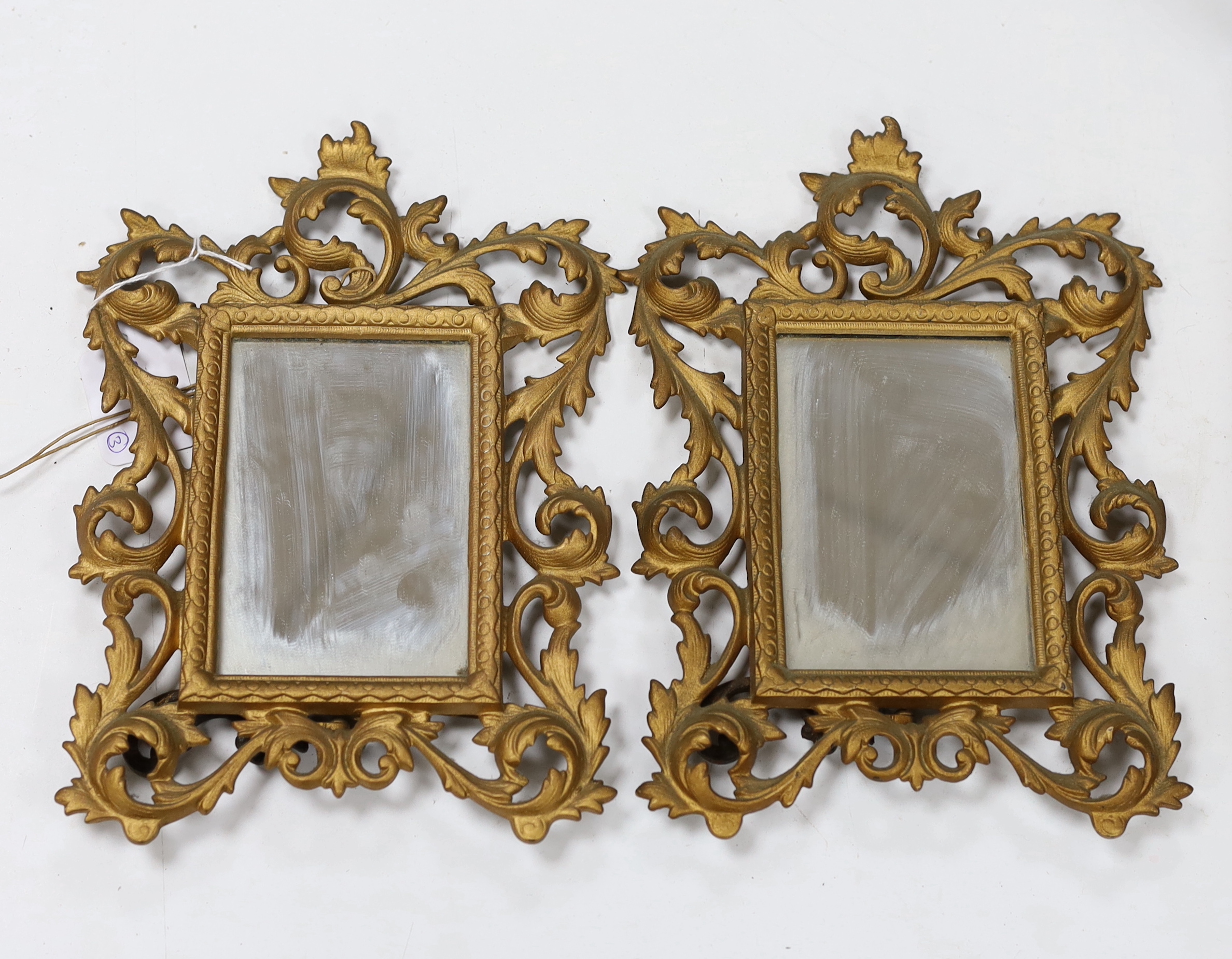 A pair of gilt metal, Rococo style easel mirrors and a carved wood photo frame, largest overall 30cm high